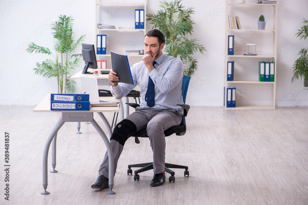 Young leg injured employee working in the office Young leg injured employee working in the office