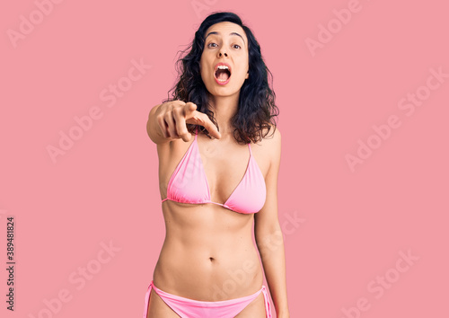 Young beautiful hispanic woman wearing bikini pointing displeased and frustrated to the camera, angry and furious with you