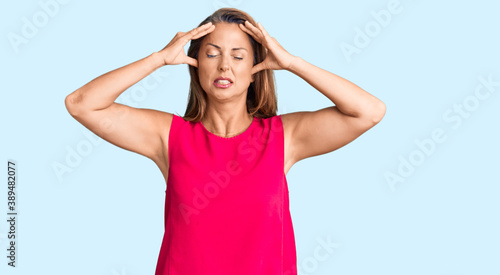 Middle age hispanic woman wearing casual clothes suffering from headache desperate and stressed because pain and migraine. hands on head.