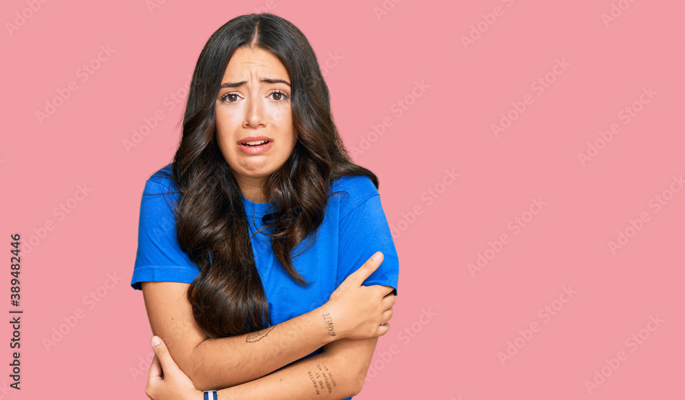 Beautiful brunette young woman wearing casual clothes shaking and freezing for winter cold with sad and shock expression on face Beautiful brunette young woman wearing casual clothes shaking and freezing for winter cold with sad and shock expression on face