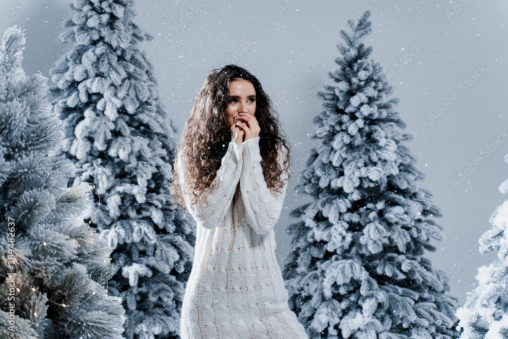 New year celebration.Happy girl with falling snow. Young woman weared in a warm white pullover and white socks. Winter holidays in snowy day New year celebration.Happy girl with falling snow. Young woman weared in a warm white pullover and white socks. Winter holidays in snowy day