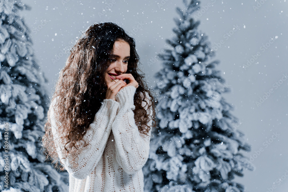 New year celebration.Happy girl with falling snow. Young woman weared in a warm white pullover and white socks. Winter holidays in snowy day New year celebration.Happy girl with falling snow. Young woman weared in a warm white pullover and white socks. Winter holidays in snowy day