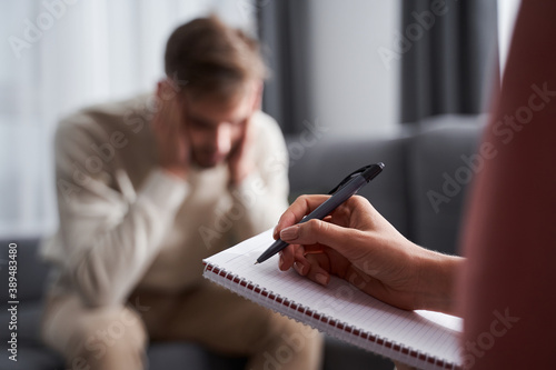 Man in depression sitting with his psychotherapist