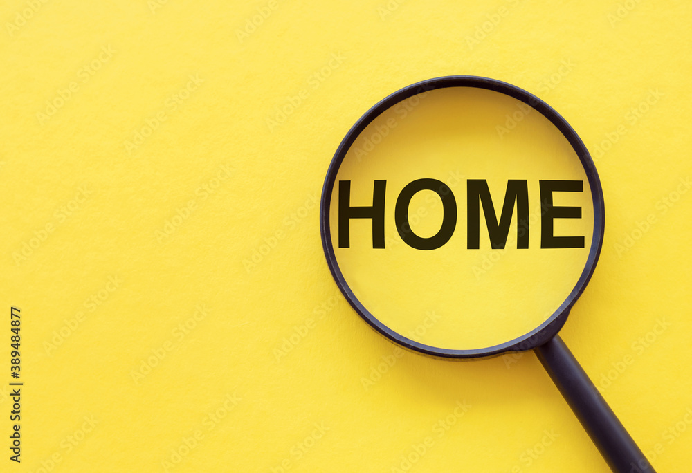 The word home is written on a magnifying glass on a yellow background. The word home is written on a magnifying glass on a yellow background.