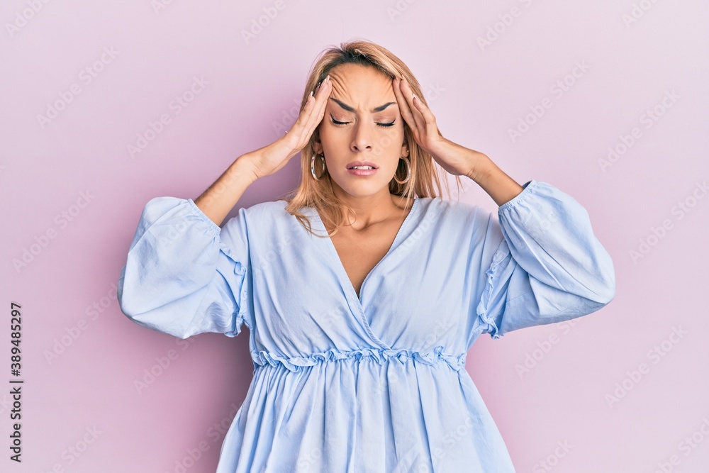 Beautiful blonde woman wearing summer dress with hand on head, headache because stress. suffering migraine. Beautiful blonde woman wearing summer dress with hand on head, headache because stress. suffering migraine.