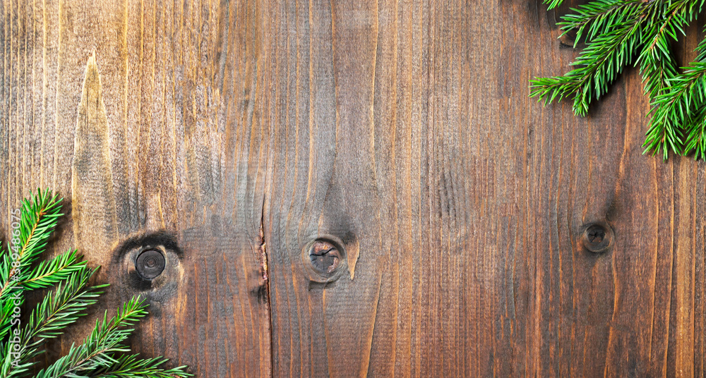 Branches of a Christmas tree on an aged wooden background. Photo with place for text for Christmas greetings. banner blank layout. Branches of a Christmas tree on an aged wooden background. Photo with place for text for Christmas greetings. banner blank layout.