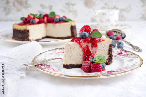 Traditional American New York cheesecake with fruits offered as close-up on design plate