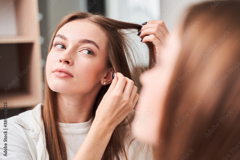 Fototapeta premium Woman looking at her reflection at the mirror