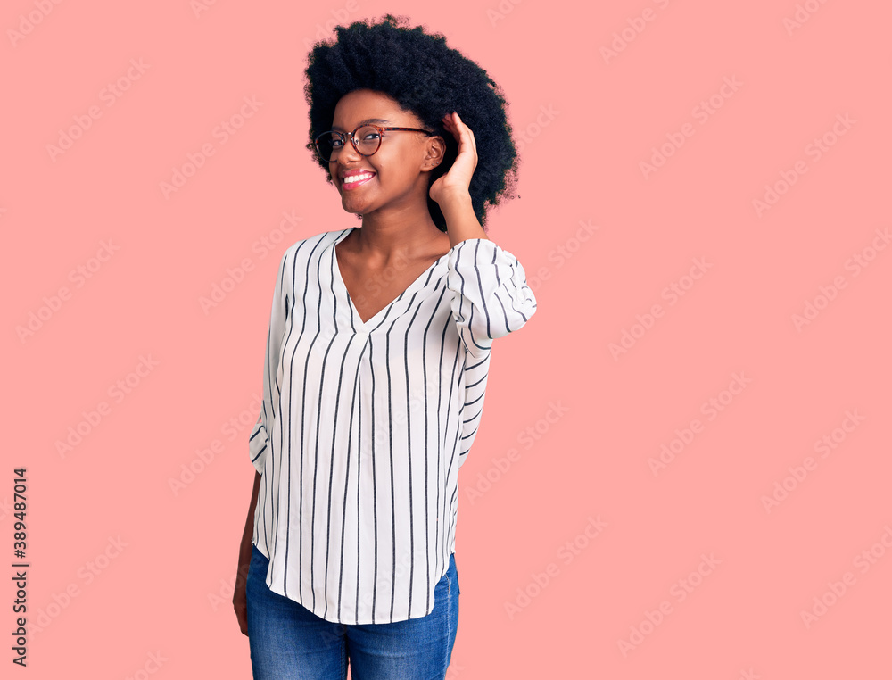 Young african american woman wearing casual clothes and glasses smiling with hand over ear listening an hearing to rumor or gossip. deafness concept. Young african american woman wearing casual clothes and glasses smiling with hand over ear listening an hearing to rumor or gossip. deafness concept.