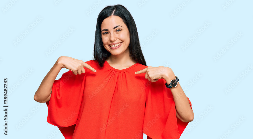 Fototapeta premium Beautiful young woman wearing casual clothes looking confident with smile on face, pointing oneself with fingers proud and happy.
