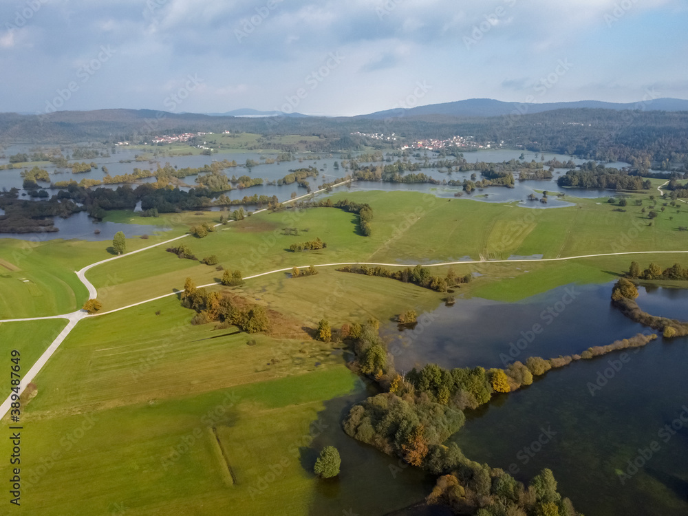 Fototapeta premium flooded valley green fields and trees forest