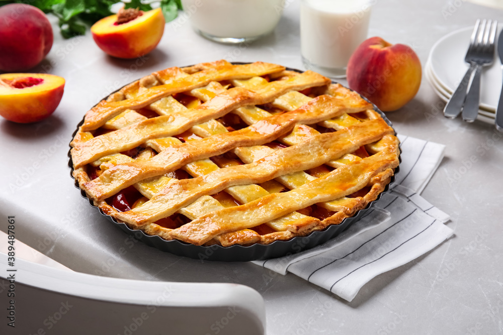 Delicious peach pie and fresh fruits on light kitchen table Delicious peach pie and fresh fruits on light kitchen table