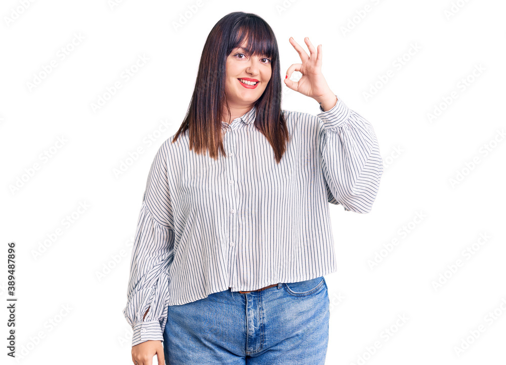 Young plus size woman wearing casual clothes smiling positive doing ok sign with hand and fingers. successful expression. Young plus size woman wearing casual clothes smiling positive doing ok sign with hand and fingers. successful expression.
