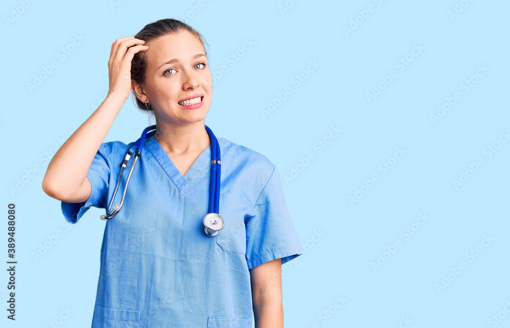Young beautiful blonde woman wearing doctor uniform and stethoscope confuse and wonder about question. uncertain with doubt, thinking with hand on head. pensive concept. Young beautiful blonde woman wearing doctor uniform and stethoscope confuse and wonder about question. uncertain with doubt, thinking with hand on head. pensive concept.