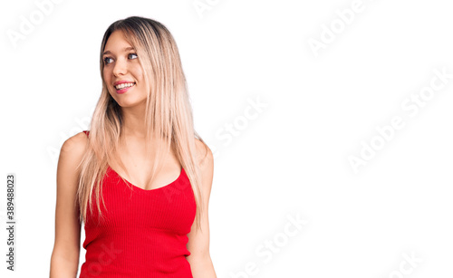 Young beautiful blonde woman wearing casual clothes looking away to side with smile on face, natural expression. laughing confident. © Krakenimages.com