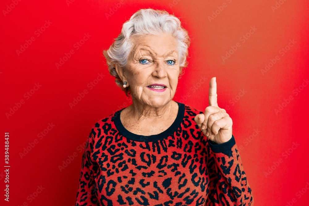 Senior grey-haired woman wearing casual clothes smiling with an idea or question pointing finger up with happy face, number one Senior grey-haired woman wearing casual clothes smiling with an idea or question pointing finger up with happy face, number one