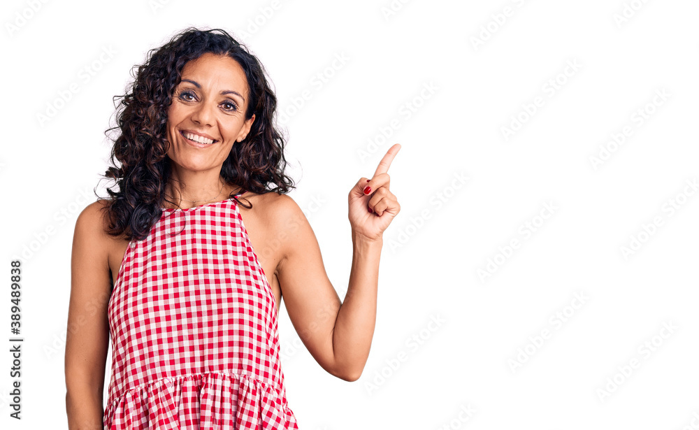 Middle age beautiful woman wearing casual sleeveless t shirt smiling happy pointing with hand and finger to the side Middle age beautiful woman wearing casual sleeveless t shirt smiling happy pointing with hand and finger to the side