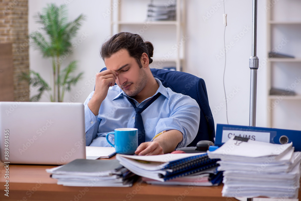 Young male employee suffering at workplace Young male employee suffering at workplace