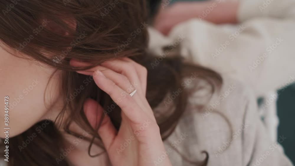 Two stylish girls in pantsuits. White interior with large windows and white chairs
