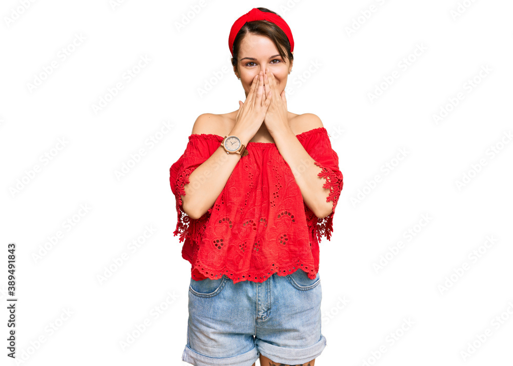 Young brunette woman with short hair wearing casual summer clothes and diadem laughing and embarrassed giggle covering mouth with hands, gossip and scandal concept Young brunette woman with short hair wearing casual summer clothes and diadem laughing and embarrassed giggle covering mouth with hands, gossip and scandal concept