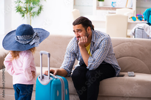 Young man and his small daughter preparing for the trip photo