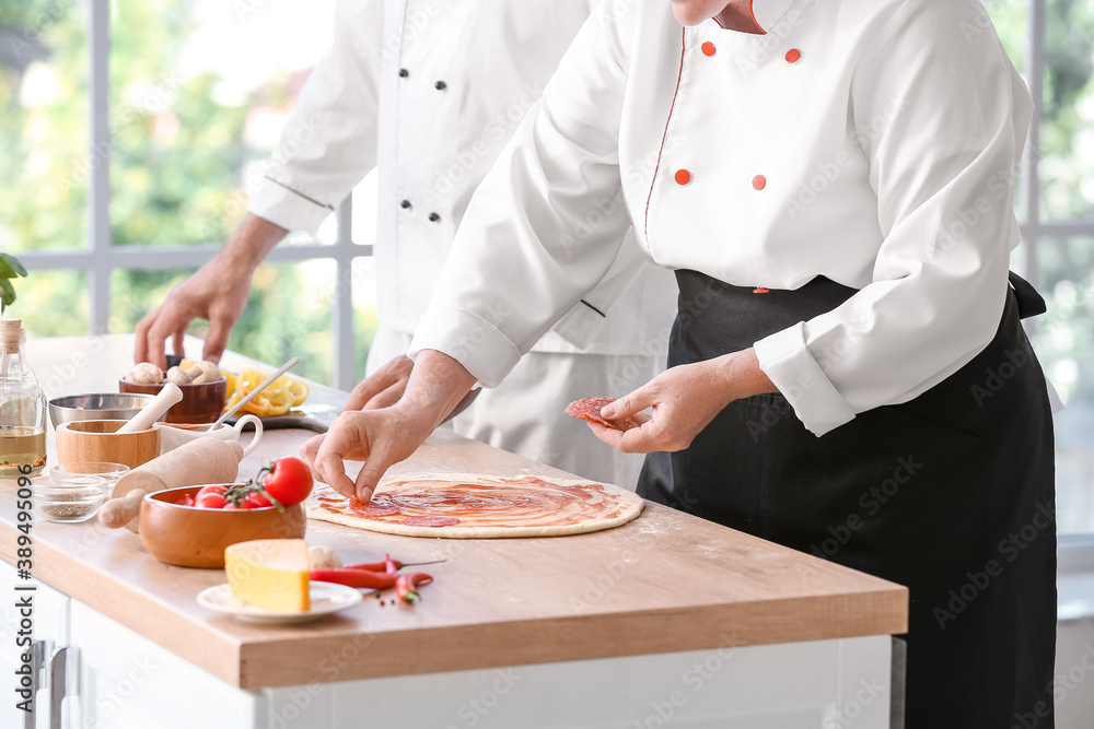 Chefs cooking tasty pizza in kitchen Chefs cooking tasty pizza in kitchen
