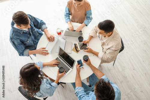 Students with modern devices studying online indoors