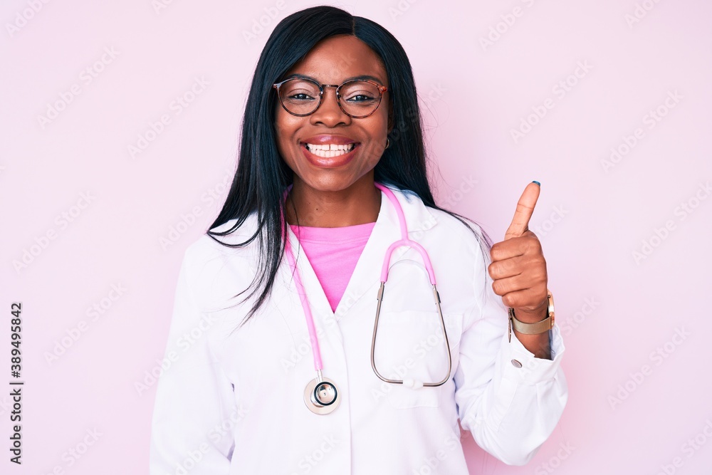 Young african american woman wearing doctor stethoscope smiling happy and positive, thumb up doing excellent and approval sign Young african american woman wearing doctor stethoscope smiling happy and positive, thumb up doing excellent and approval sign