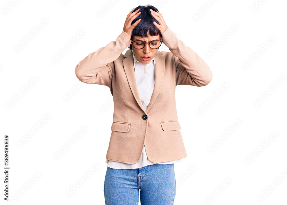 Young brunette woman with short hair wearing business jacket and glasses suffering from headache desperate and stressed because pain and migraine. hands on head. Young brunette woman with short hair wearing business jacket and glasses suffering from headache desperate and stressed because pain and migraine. hands on head.