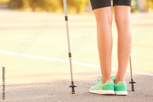 Young woman training with walking poles outdoors
