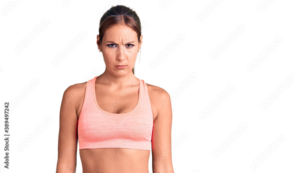 Young beautiful hispanic woman wearing sportswear skeptic and nervous, frowning upset because of problem. negative person. Young beautiful hispanic woman wearing sportswear skeptic and nervous, frowning upset because of problem. negative person.