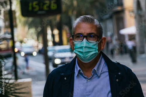 Portrait of a handsome Caucasian man in his 50s walking down a city street during the coronavirus pandemic. 