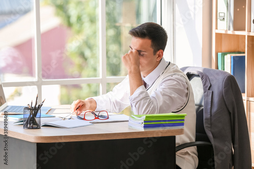 Stressed young male teacher...