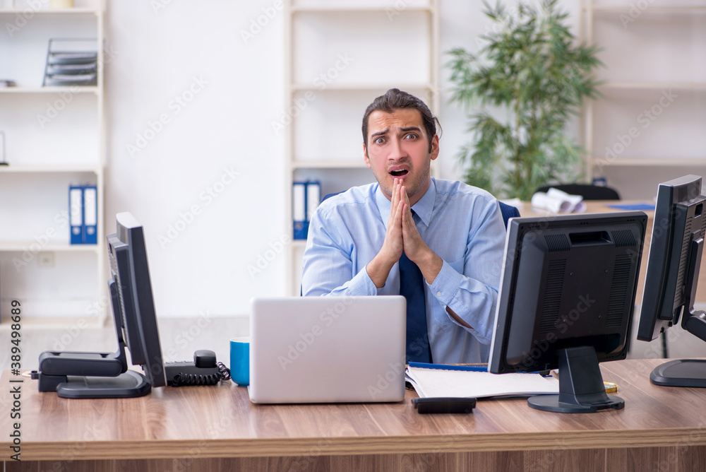 Young male employee unhappy with excessive work Young male employee unhappy with excessive work