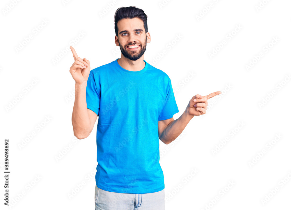 Young handsome man with beard wearing casual t-shirt smiling confident pointing with fingers to different directions. copy space for advertisement Young handsome man with beard wearing casual t-shirt smiling confident pointing with fingers to different directions. copy space for advertisement