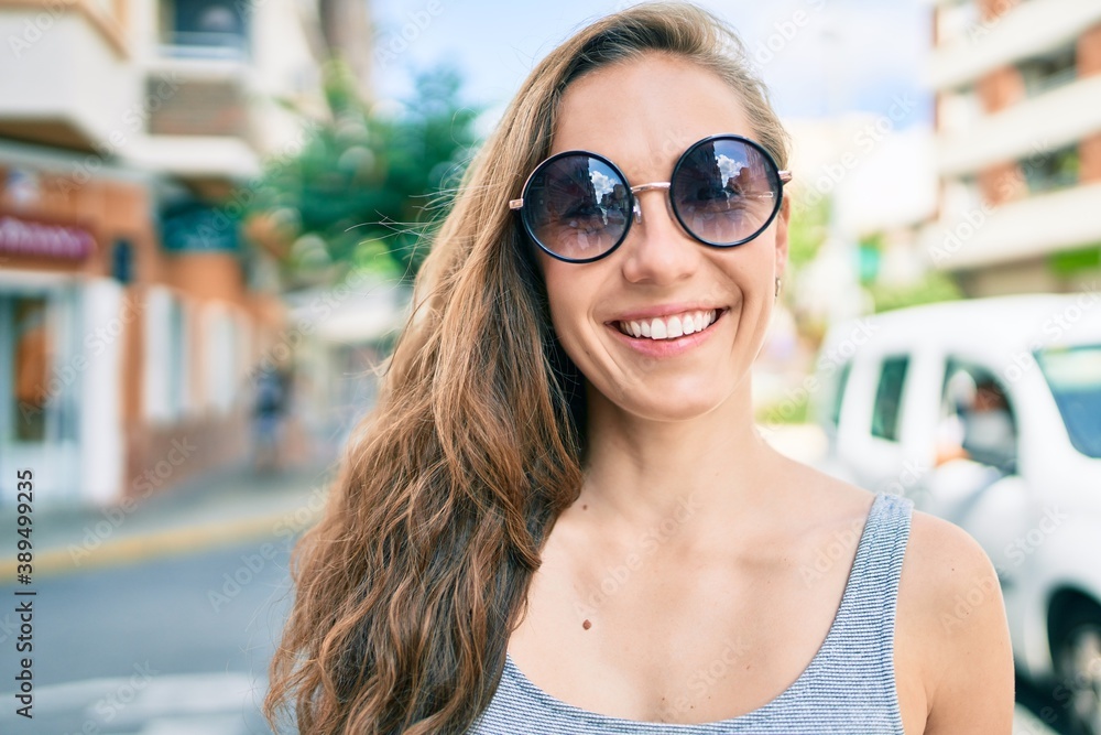 Young blonde woman smiling happy walking at street of city Young blonde woman smiling happy walking at street of city