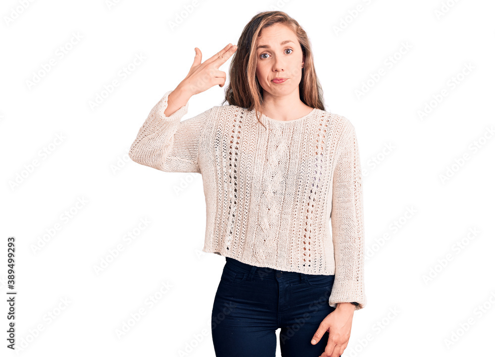 Young beautiful blonde woman wearing casual sweater shooting and killing oneself pointing hand and fingers to head like gun, suicide gesture. Young beautiful blonde woman wearing casual sweater shooting and killing oneself pointing hand and fingers to head like gun, suicide gesture.