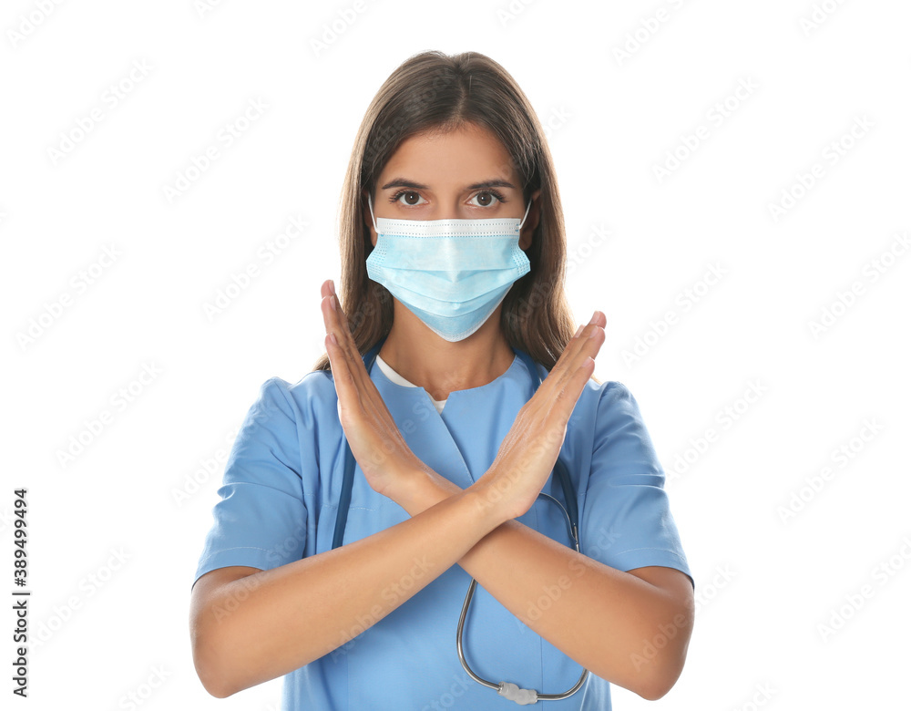 Doctor in protective mask showing stop gesture on white background. Prevent spreading of coronavirus Doctor in protective mask showing stop gesture on white background. Prevent spreading of coronavirus