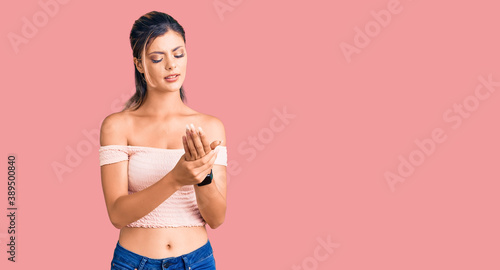 Young beautiful woman wearing casual clothes suffering pain on hands and fingers, arthritis inflammation
