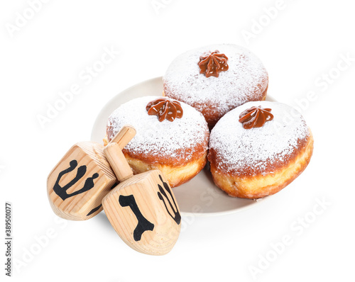 Dreidels and donuts for Hanukkah on white background