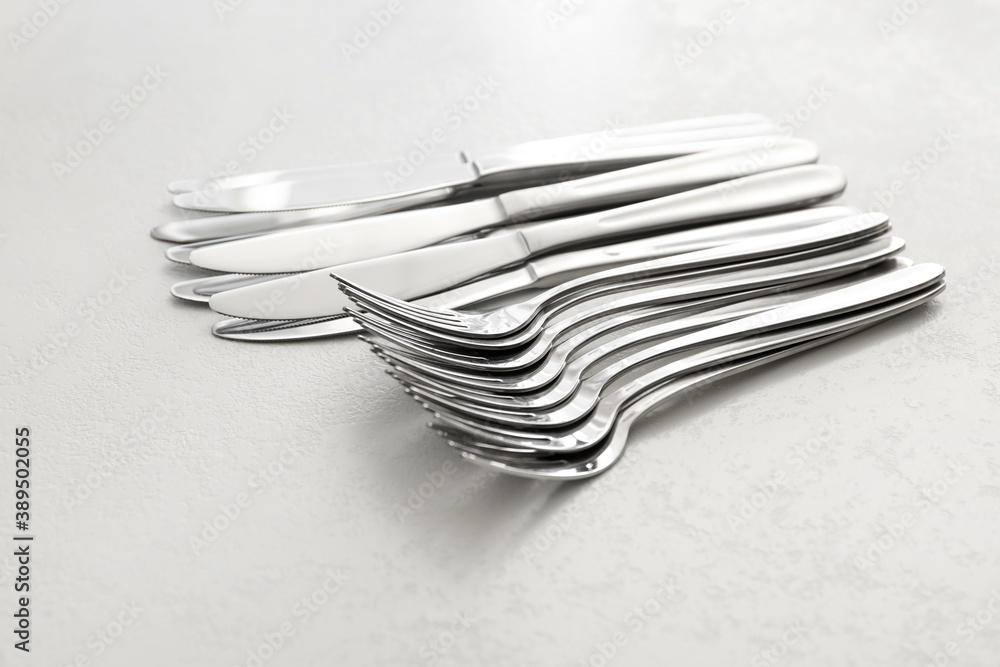 Knives and forks on white table, closeup Knives and forks on white table, closeup