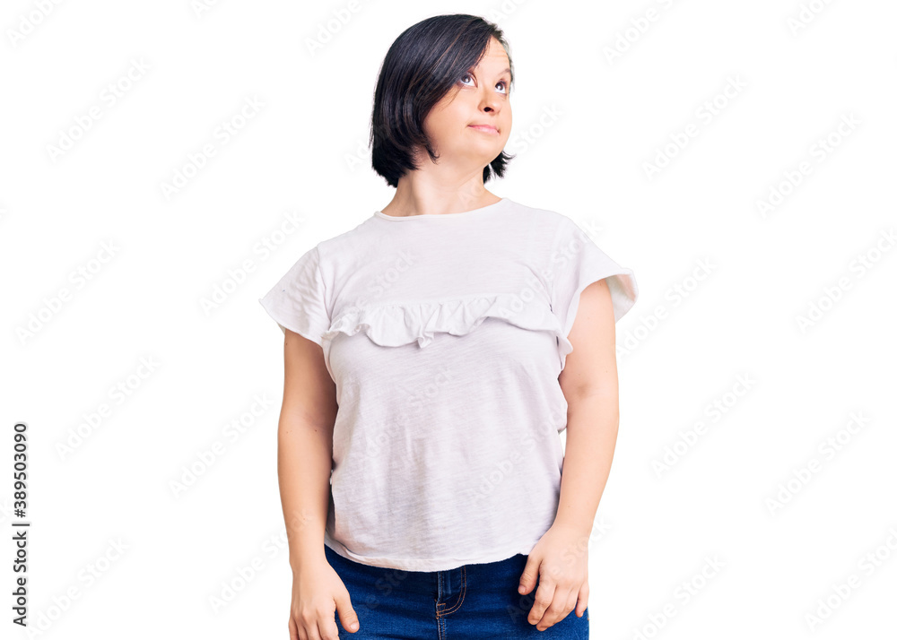 Brunette woman with down syndrome wearing casual white tshirt smiling looking to the side and staring away thinking. Brunette woman with down syndrome wearing casual white tshirt smiling looking to the side and staring away thinking.