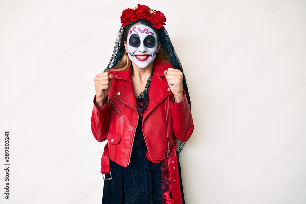 Woman wearing day of the dead costume over white excited for success with arms raised and eyes closed celebrating victory smiling. winner concept. Woman wearing day of the dead costume over white excited for success with arms raised and eyes closed celebrating victory smiling. winner concept.
