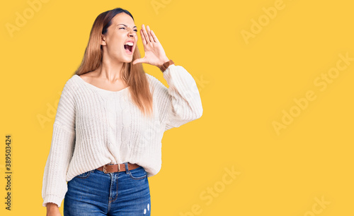 Beautiful young woman wearing casual clothes shouting and screaming loud to side with hand on mouth. communication concept.