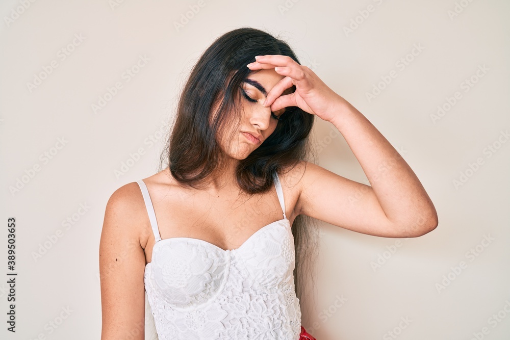 Brunette teenager girl posing elegant tired rubbing nose and eyes feeling fatigue and headache. stress and frustration concept. Brunette teenager girl posing elegant tired rubbing nose and eyes feeling fatigue and headache. stress and frustration concept.