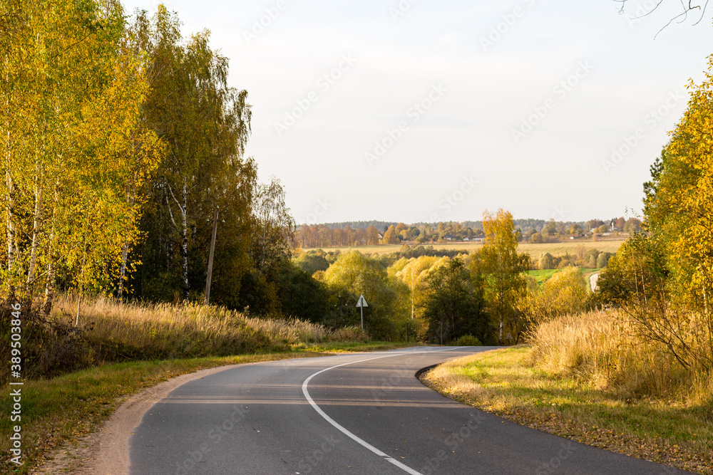 Fototapeta premium A two-lane road passing through a picturesque area. A sharp right turn on the road 