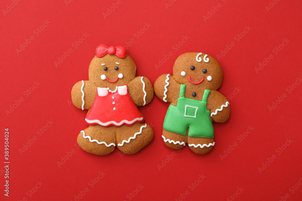 Christmas human shaped gingerbread cookies on red background, flat lay