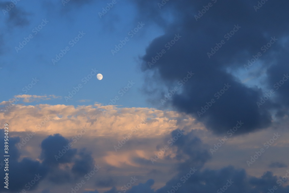 View of the evening sky with clouds and moon View of the evening sky with clouds and moon