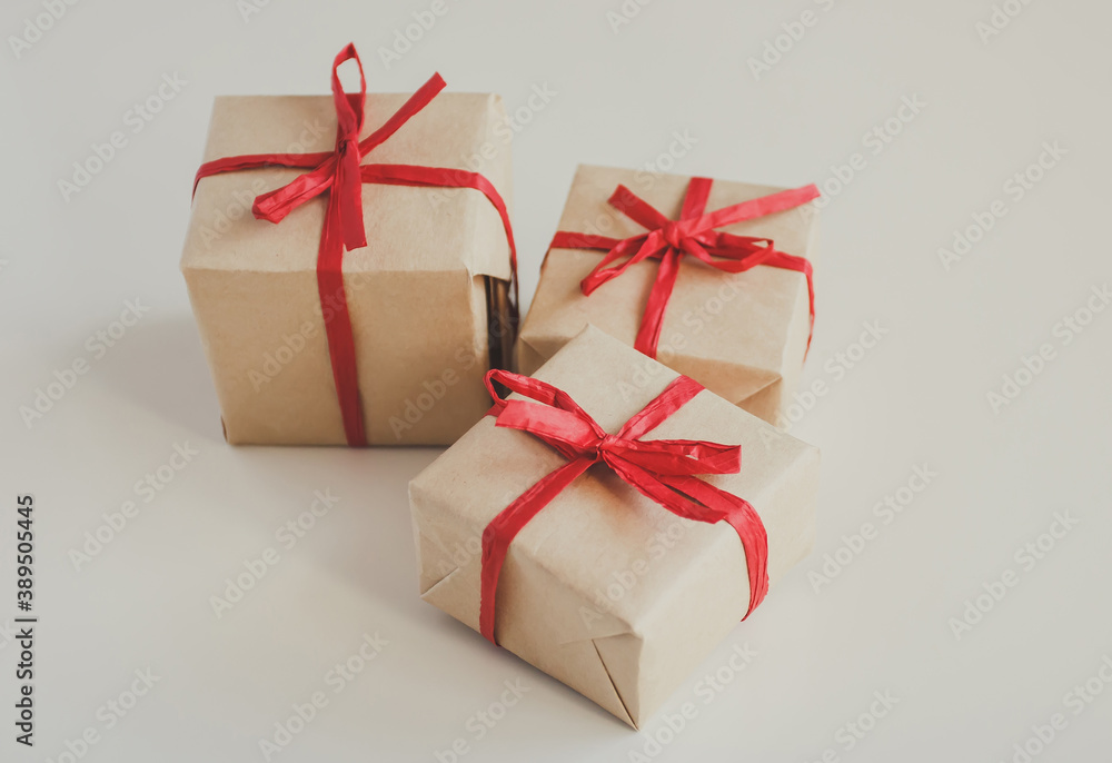 Gift boxes made from craft paper with red ribbon on white background Gift boxes made from craft paper with red ribbon on white background