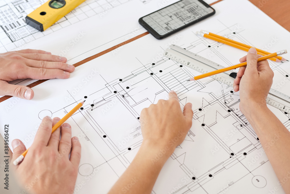 Hand of young female engineer with pencil pointing at sketch of new building Hand of young female engineer with pencil pointing at sketch of new building